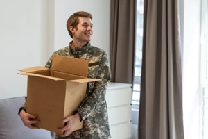 smiling army officer holding packing carton