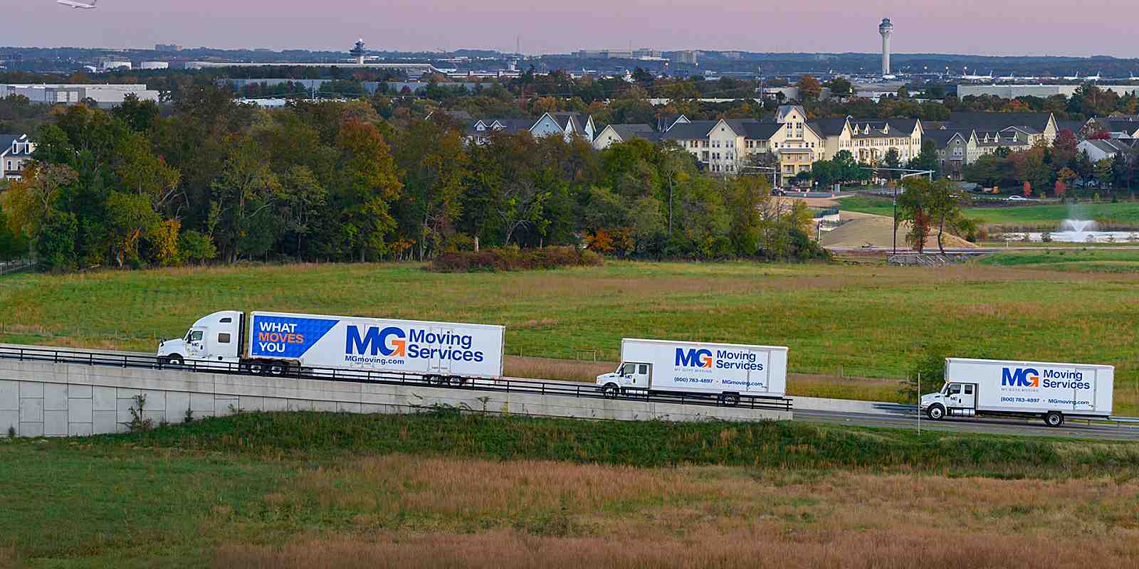 three mg moving trucks on the road