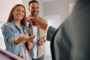 estate agent giving keys to a newly married couple